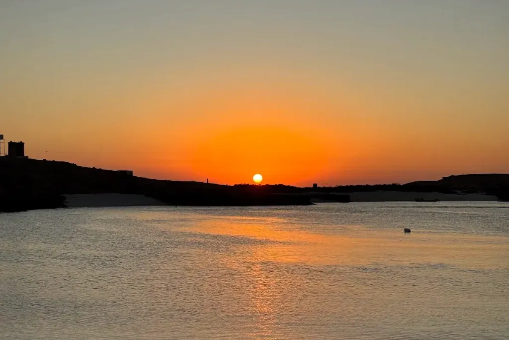 Orange sunset over calm water at the Daymaniyat Islands
