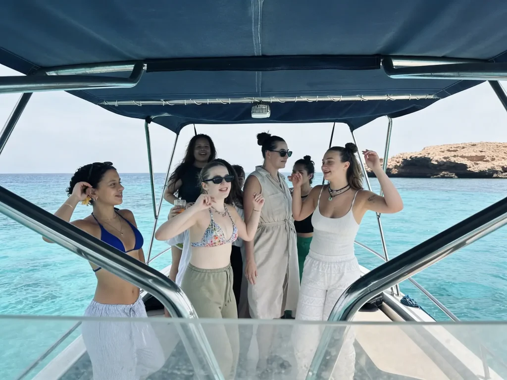 Guests standing under the boat canopy enjoying the sea views near the Daymaniyat Islands
