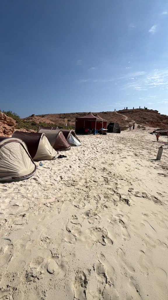 A row of camping tents and a shade shelter along the beach at the island camp, Daymaniyat Islands